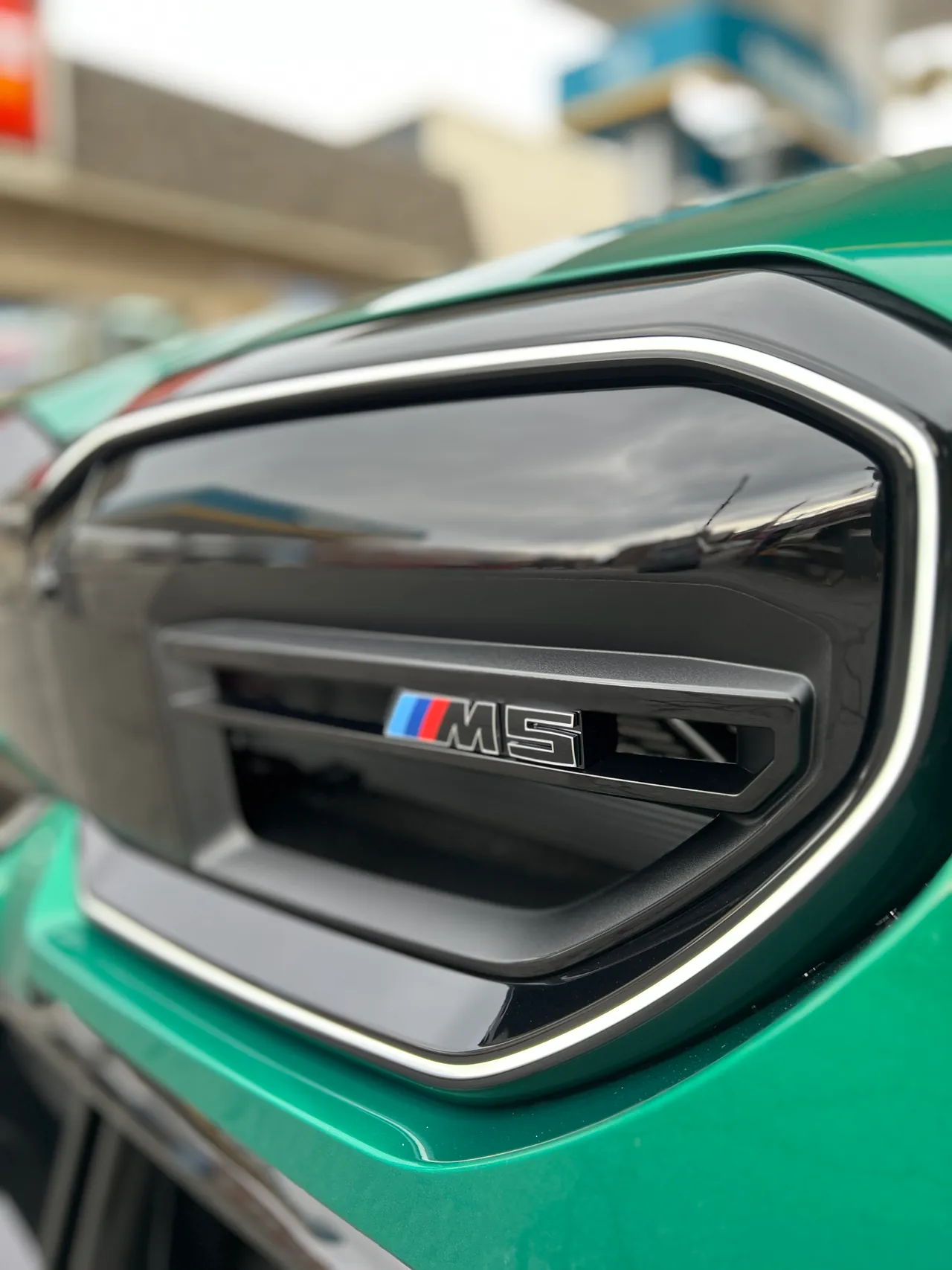 Close detail of a side vent badge on a green sedan
