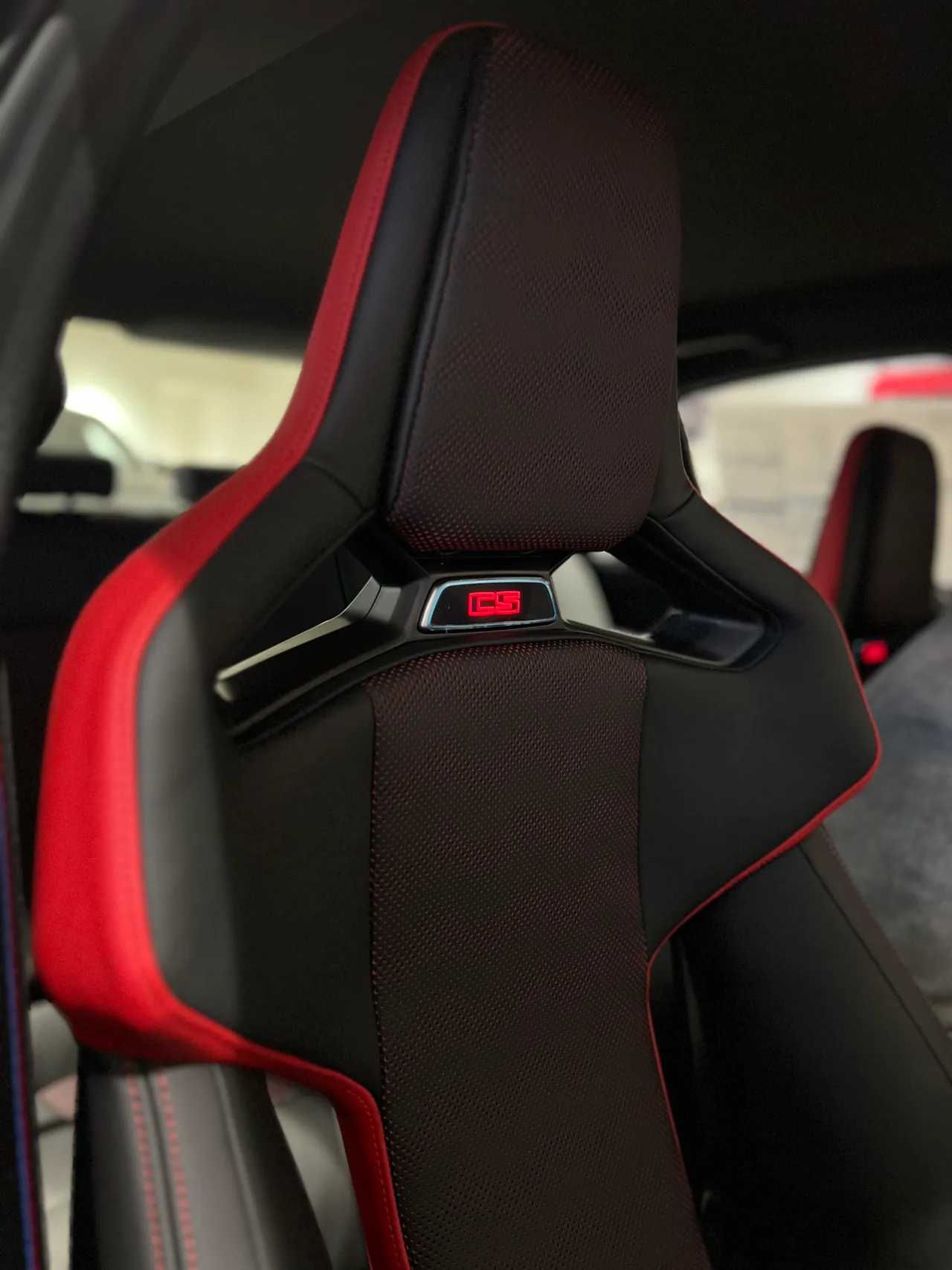 Black and red sport bucket seat with an illuminated headrest badge